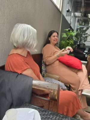 Duas profissionais de saúde conversando em um banco de madeira em ambiente humanizado com jardim na Saúde Integrada, em São Bernardo do Campo.