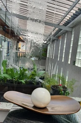 Design biofílico em clínica de saúde com parede de plantas vivas, elementos em madeira e iluminação suave.