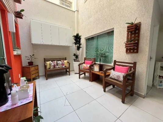 Espaço Gourmet da Saúde Integrada com iluminação natural, bancos de madeira, almofadas coloridas e área de café, seguindo princípios de neuroarquitetura e biofilia em São Bernardo do Campo.